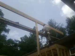 Carpenter setting a ridge beam over a new addition frame — Ice Dam Removal by Roofing Brothers in Hamburg
