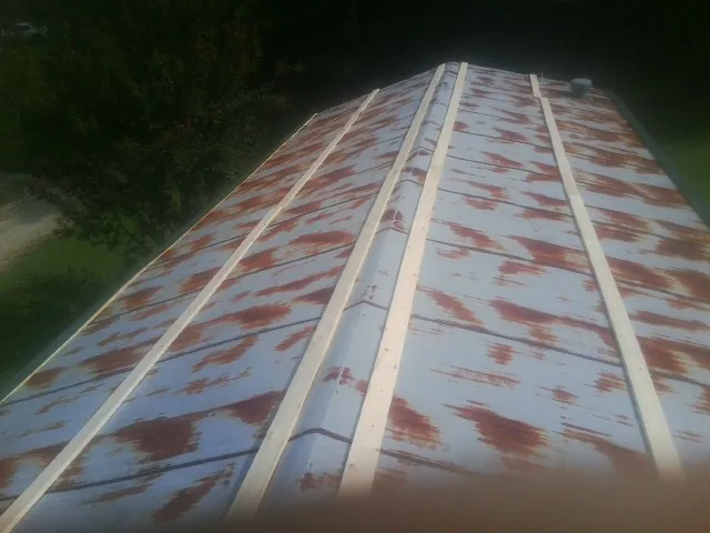 Rusted metal roof panels with new wood purlins before replacement — Storm Damage Roof Repair in Hamburg by Roofing Brothers