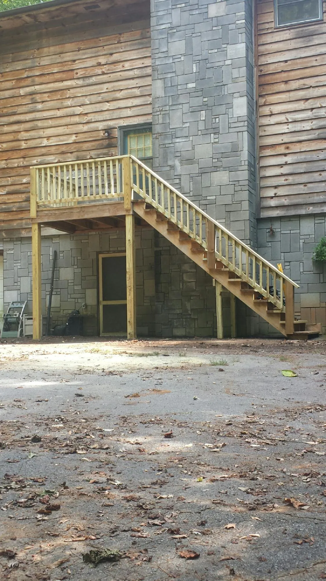 New pressure treated deck and stair landing on a log home in Hamburg